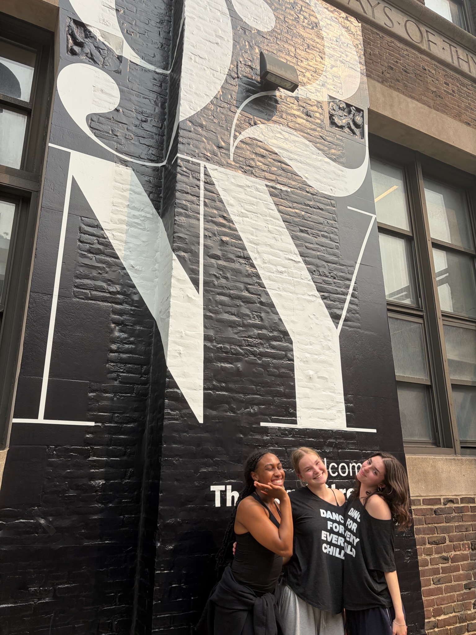 three students in front of building with 92NY painted on it
